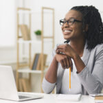 Young Afro Business Lady Smiling Sitting In Modern Office