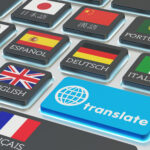 Foreign languages translation concept, online translator, macro view of computer keyboard with national flags of world countries on keys and blue translate button