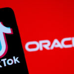 Smartphone with Tik Tok logo is seen in front of displayed Oracle logo in this illustration